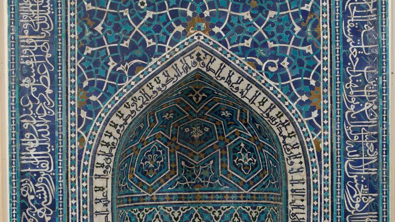 Blue and turquoise glazed tile mosaic of a mihrab, a prayer niche, from Isfahan, Iran, dated 1354–55, with a pointed arch framed by bands of Arabic calligraphy