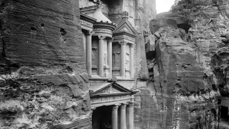 Al Khazneh, the rock-cut Treasury at Petra in Jordan, seen between the sandstone walls of the Siq in an early 20th-century photograph
